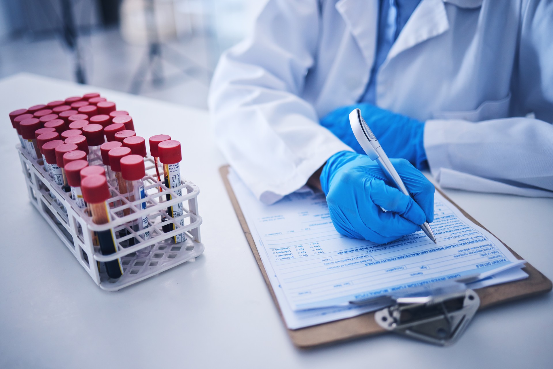 Blood test, medicine documents and hands in laboratory for healthcare planning, science review or checklist. Scientist, report and writing medical results of dna investigation, paperwork and research